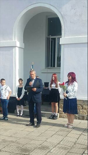 Директорът и учители по време на тържеството пред училището